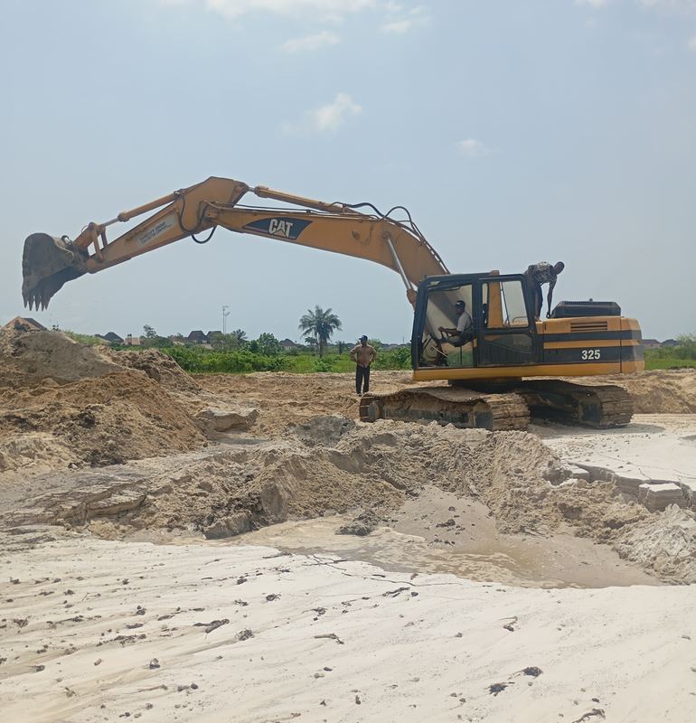 Tracked excavator handling fill at the reclamation front