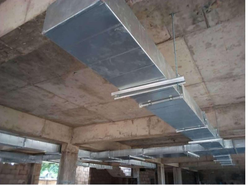 Galvanised ductwork routed beneath the slab