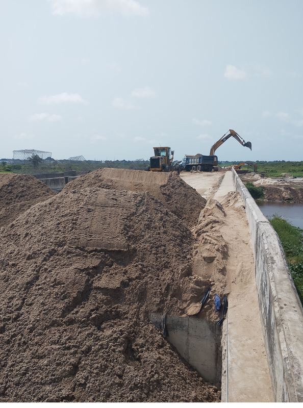 Sand fill placed against the channel lining, with plant at the working front